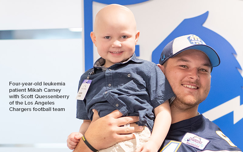 Four-year-old ALL patient Mikah Carney with Scott Quessenberry of the Los Angeles Chargers football team